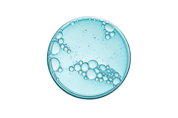 Photo of Abstract petri dish with cosmetic or medical liquid isolated on white background top view.