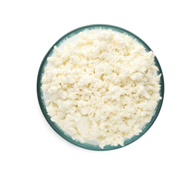istock Delicious fresh cottage cheese in bowl isolated on white, top view 1399179038
