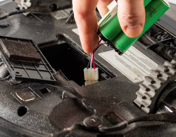 istock the serviceman changes the faulty battery in the robot vacuum cleaner. 1399179090