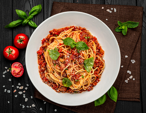 Traditional italian spaghetti bolognese on a dark background. Serving food in a restaurant. Healthy food concept. Photo for the menu