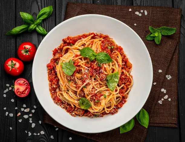 Photo of Traditional italian spaghetti bolognese on a dark background