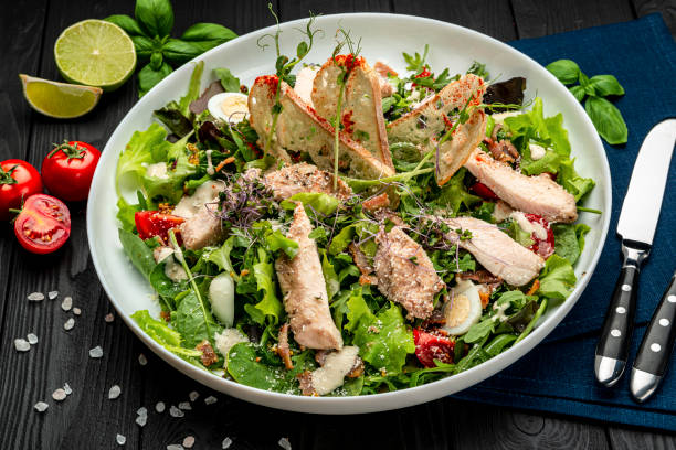 istock Fresh caesar salad in white plate on dark wooden table. 1399179451