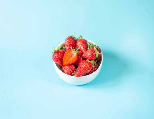 istock Fresh organic strawberries in pot on light blue background 1399180498