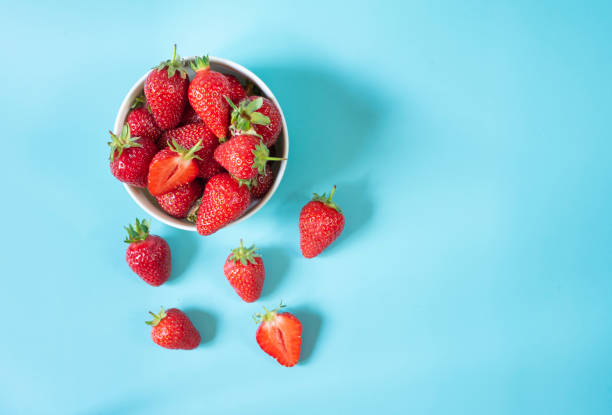 istock Fresh organic strawberries in pot on light blue background 1399180634