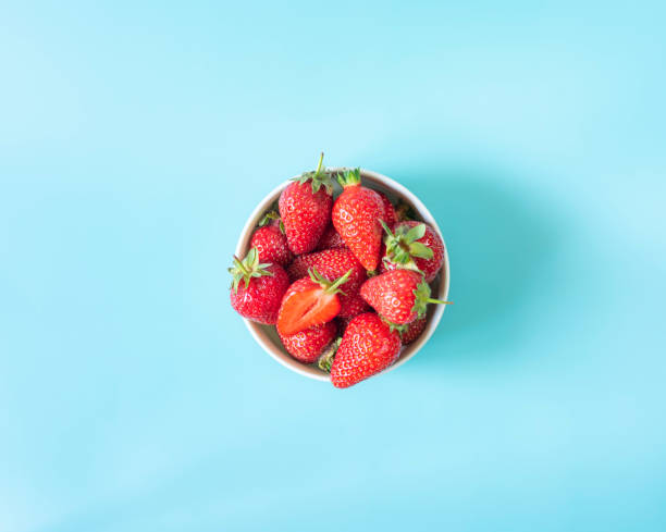istock Fresh organic strawberries in pot on light blue background 1399180636