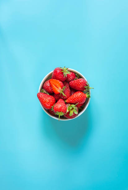 istock Fresh organic strawberries in pot on light blue background 1399180754