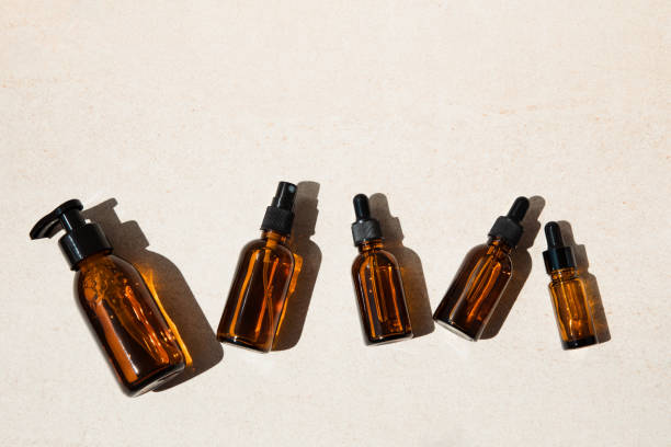 istock Clear brown bottles with natural cosmetics on a beige stone background 1399181504