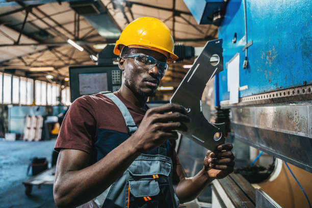 istock Worker in uniform operating in manual lathe in metal big workshop 1399184575