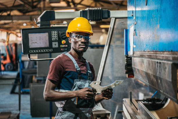 istock Worker in uniform operating in manual lathe in metal big workshop 1399184576