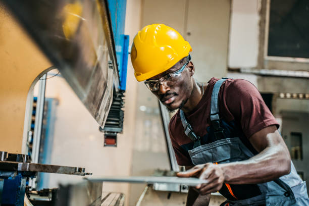 istock Worker in uniform operating in manual lathe in metal big workshop 1399184602