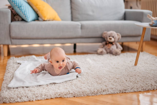 Close-up of a newborn baby boy lying down on the rug in the living room.