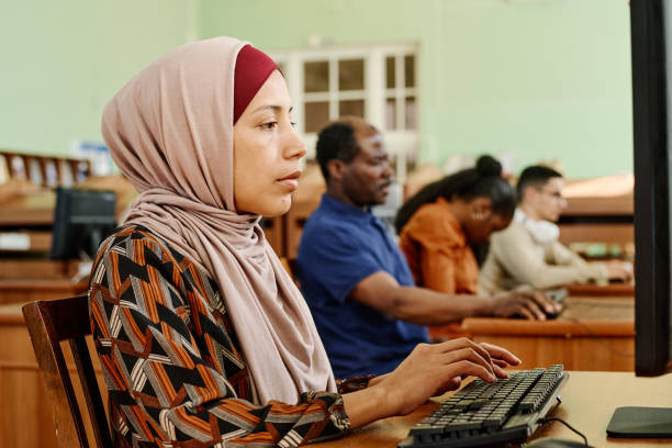 мусульманка отправляет текстовые сообщения на компьютере - women middle eastern ethnicity islam hijab стоковые фото и изоб�ражения