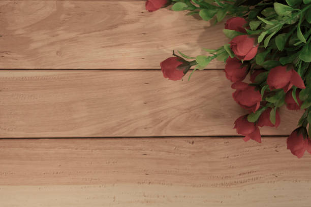 Wooden surface and red roses bouquet flat lay with copy space. Directly above.