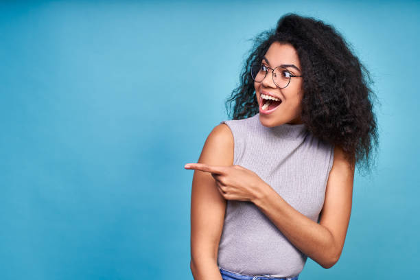 istock Attractive cheerful dark skinned woman shows direction. 1399188433