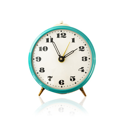 Old mechanical alarm clock isolated on white background with reflection. Vintage blue metal classic analog alarmclock, retro watch isolate. Front view.