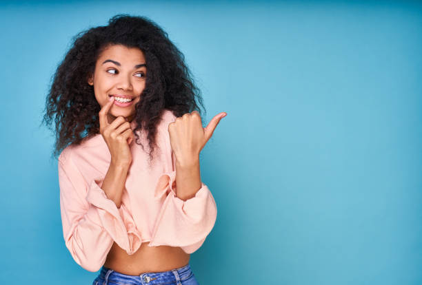 istock Hilarious playful African points her finger to the right. 1399189506