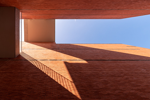 Sunlight refracts light and shadow through the gaps of red brick buildings