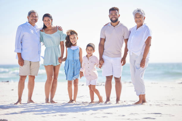 istock Multi generation family on holding hands while standing on the beach together. Mixed race family with two children, two parents and grandparents spending time together by the sea 1399190145