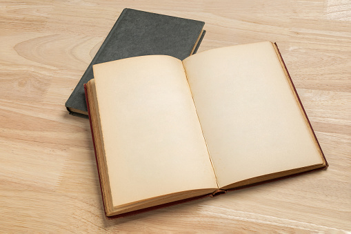 stack of open old book on wooden table for mockup blank template