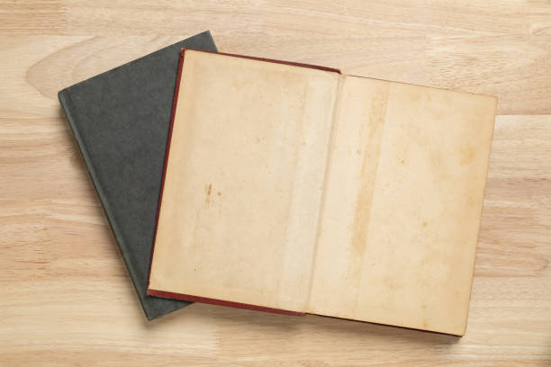 istock stack of open old book on wooden table for mockup blank template 1399193171