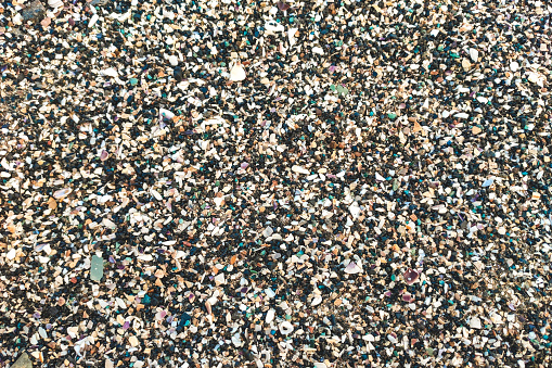 texture of pebbles and small seashells on the beach.