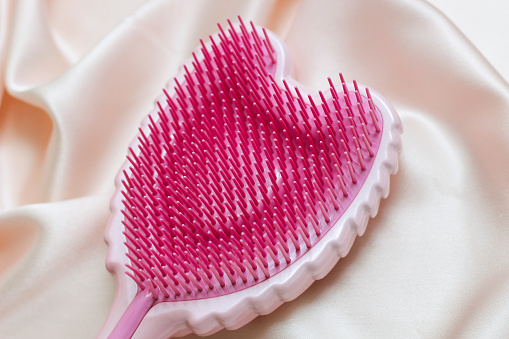 Cherkassy, Ukraine - January, 10, 2021. Tangle Angel hair combs on silk pink background