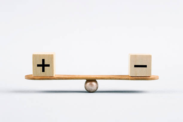 Seesaw and cubes with plus and minus sign stock photo