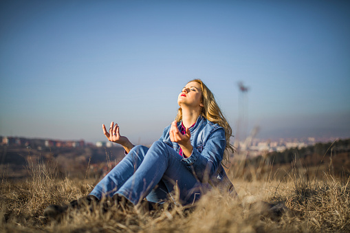 blonde woman relaxing on top of the hill