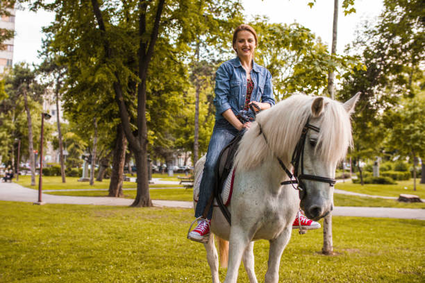 Young blonde woman riding a horse