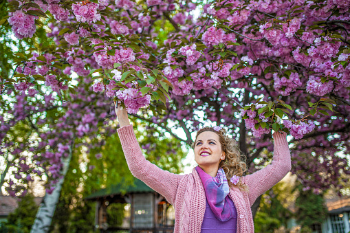 Blonde woman in spring cherry garden