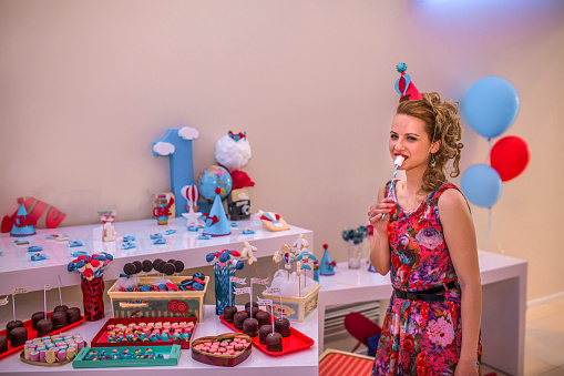 Woman choosing what sweets to eat first at her birthday party