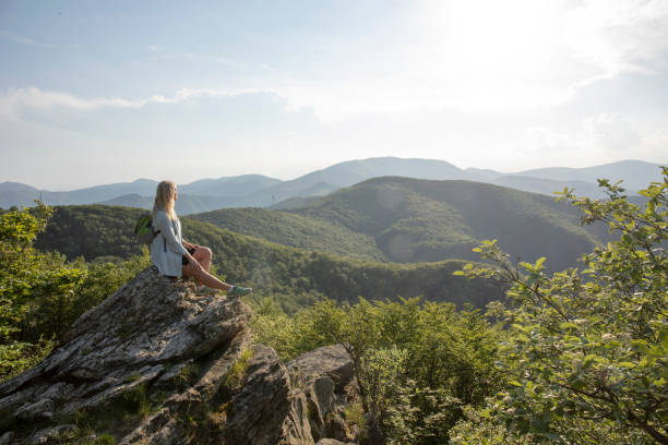 istock Female hiker relaxes at viewpoint, at sunrise 1399202155