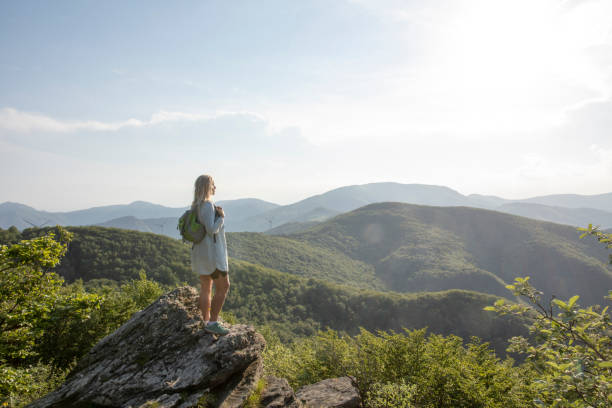 istock Female hiker relaxes at viewpoint, at sunrise 1399202327
