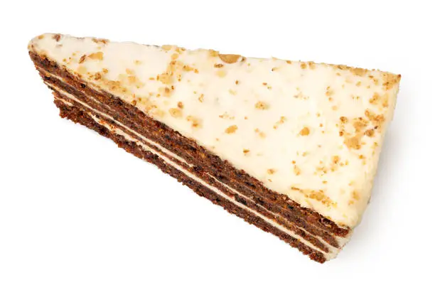 Slice of carrot cake with cream cheese filling and frosting isolated on white. Top view.