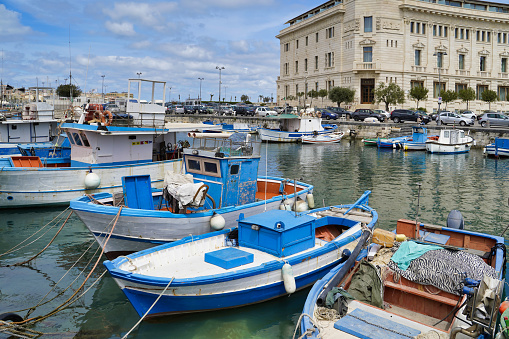 Sicily, Italy - April 13, 2022: Sea coast with moored boats and fishing boats. Fishing village.
