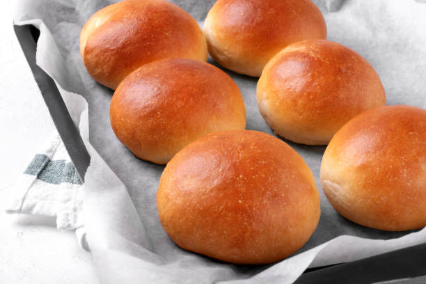 panini di lievito dorati sulla teglia del forno - pan brioche foto e immagini stock