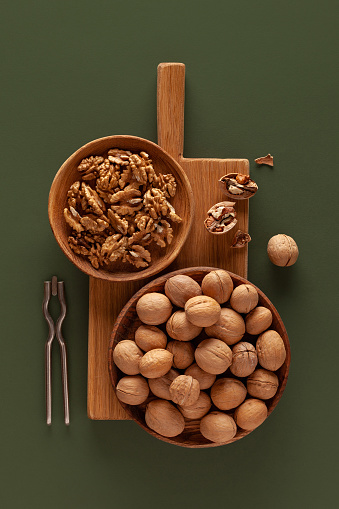 Close-up of walnuts and nutcracker on a green background