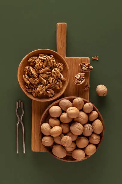 Close-up of walnuts and nutcracker on a green background