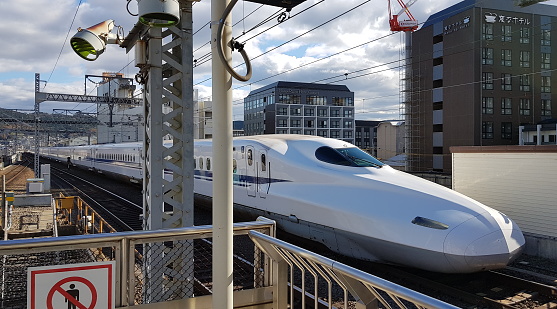 Shinkansen N700 X71 approaching the Kyoto Station. Blue sky sunny day. Kyoto, Japan.