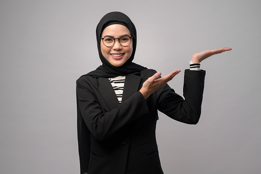 A beautiful muslim woman wearing glasses over white background studio