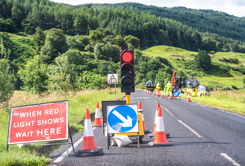 Traffic lights showing red at temporary roadworks site on an A road in Scotland.