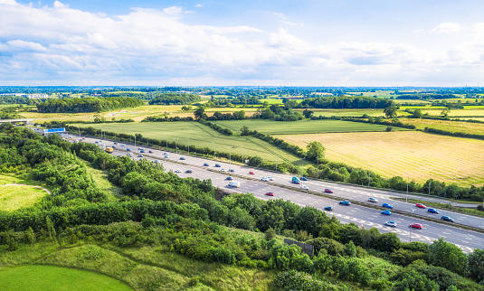 An aerial view of a straight section of the M1 motorway through the English Midlands.