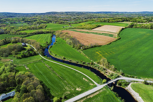 Aerial drone view of farmland alongside a river.