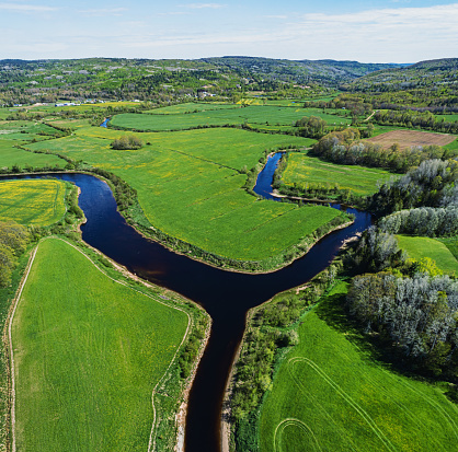 Aerial drone view of farmland alongside branches of a river.