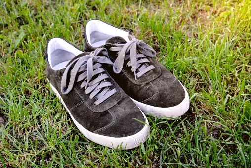 Black sneakers on green grass.