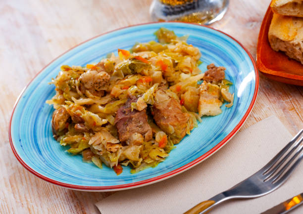 istock Appetizing cabbage stewed with pork meat on white plate 1399213166