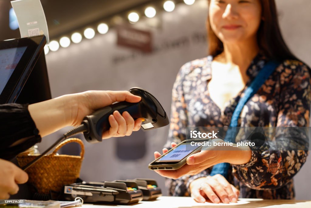 Lady checking out with digital payment at the counter Woman checking out using digital payment at zero waste store Internet Stock Photo