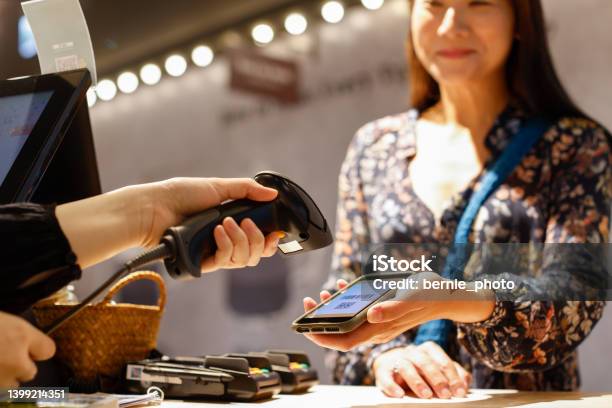 Lady Checking Out With Digital Payment At The Counter Stock Photo - Download Image Now