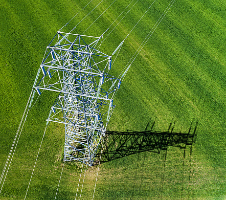 Aerial drone view of a high voltage power line in a rural landscape.