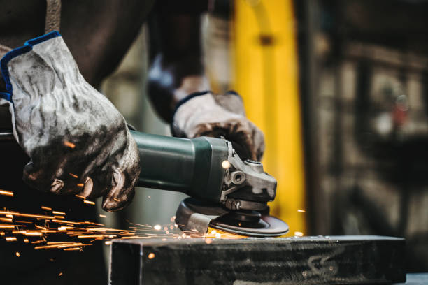 welder grinding peace of metal - protective glove machinist human hand african descent imagens e fotografias de stock